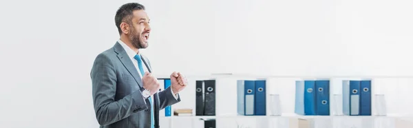 Handsome businessman standing and showing yes gesture in office — Stock Photo