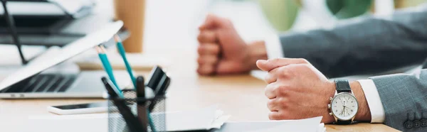 Visão cortada de homem de negócios à mesa com laptop e smartphone no escritório — Fotografia de Stock