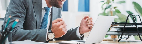 Vista ritagliata di uomo d'affari seduto a tavola con computer portatile e mostrando sì gesto in ufficio — Foto stock