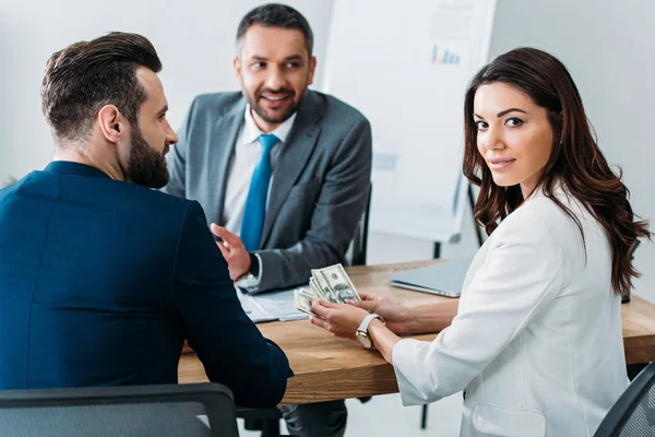 Selective focus of investor in suit holding money at office — Stock Photo