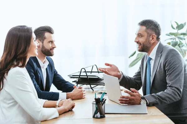 Conselheiro bonito em terno conversando com investidores no local de trabalho — Fotografia de Stock