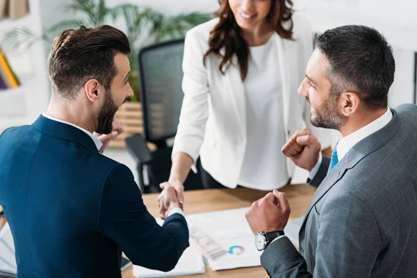 Enfoque selectivo de asesor e inversor guapo estrechando la mano en el lugar de trabajo — Stock Photo