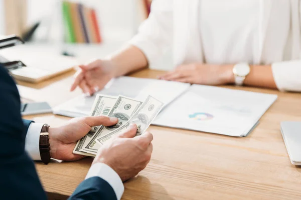 Selektiver Fokus des Mannes, der Dollar-Banknoten im Büro hält — Stockfoto