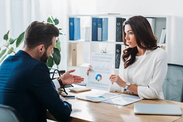 Schöner Berater, der Dokument und Anleger in Klage hält und mit der Hand darauf zeigt — Stockfoto