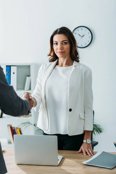 Beautiful advisor and investor in suits shaking hands at workspace — Stock Photo