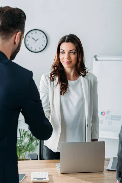 Selective focus of advisor shaking hands with investor at workplace — Stock Photo