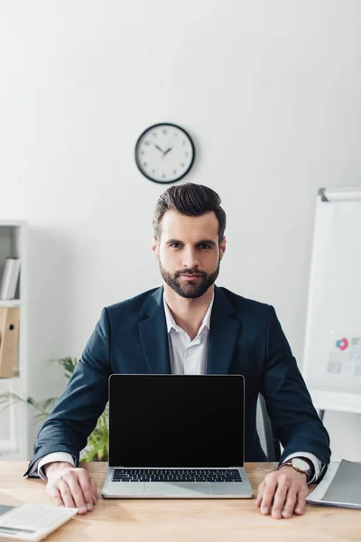 Bello consigliere in tuta che mostra computer portatile con spazio di copia — Foto stock