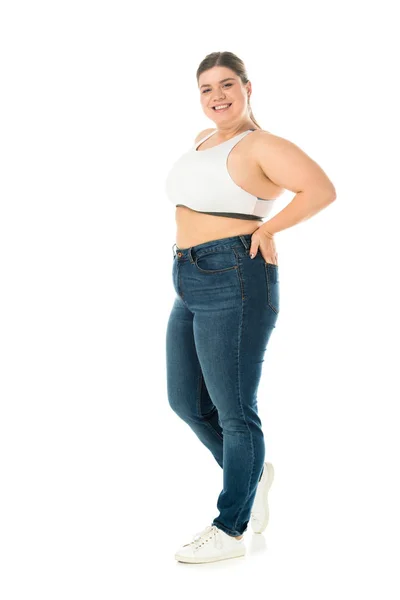 Felice donna in sovrappeso sorridente in jeans in posa con mano in tasca isolato su bianco, concetto di positività del corpo — Foto stock