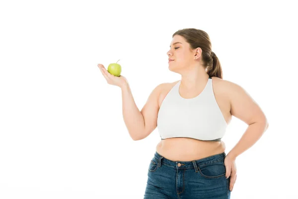 Happy smiling overweight woman looking at green apple isolated on white — Stock Photo