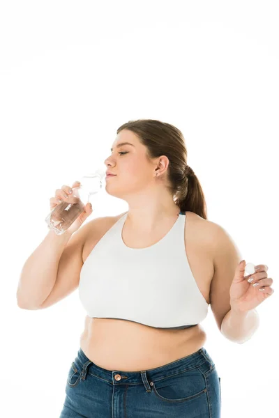 Overweight woman drinking water from bottle isolated on white — Stock Photo