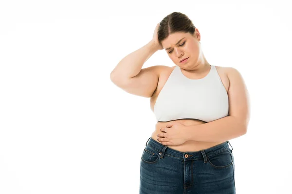 Sad overweight woman in denim touching belly isolated on white — Stock Photo