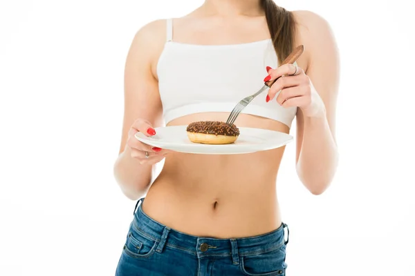 Cropped view of slim woman holding sweet delicious doughnut on plate isolated on white — Stock Photo
