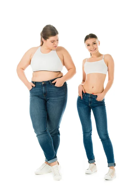 Sad overweight woman jealously looking at smiling slim beautiful woman isolated on white — Stock Photo