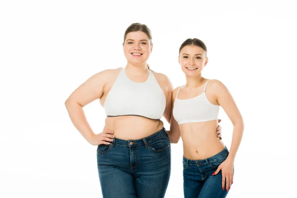 Mujeres delgadas y con sobrepeso feliz abrazo aislado en blanco, concepto de positividad corporal - foto de stock