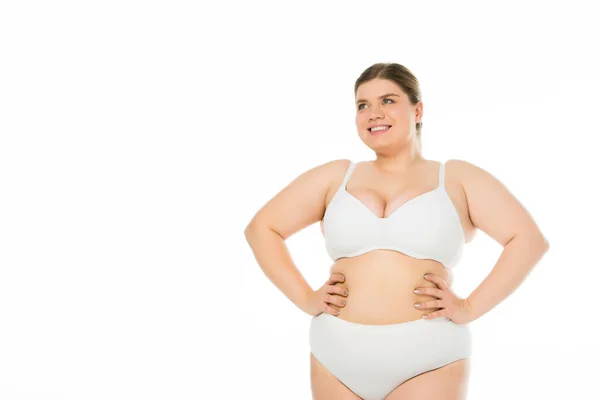 Lächelndes übergewichtiges Mädchen in Unterwäsche mit den Händen an den Hüften isoliert auf weißem, Body Positivity Konzept — Stockfoto