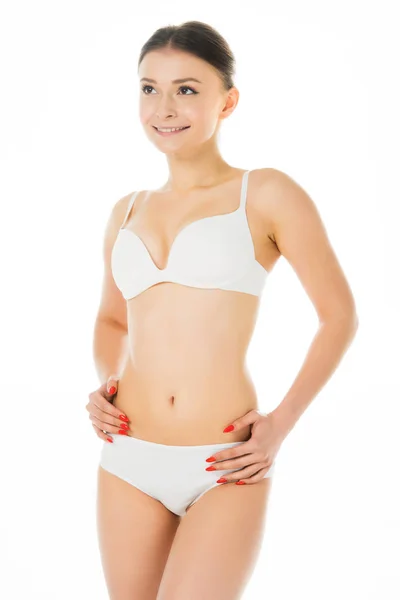 Attractive smiling girl in underwear with hands on hips isolated on white — Stock Photo