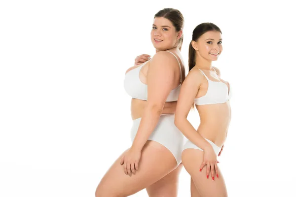 Young slim and overweight women in underwear posing together isolated on white — Stock Photo