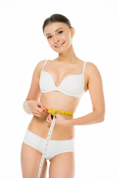 Happy slim woman measuring waist with centimeter isolated on white — Stock Photo