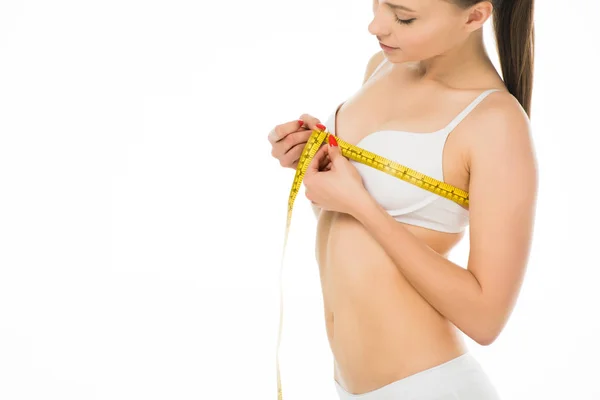Sexy slim woman in underwear measuring bust with centimeter isolated on white — Stock Photo