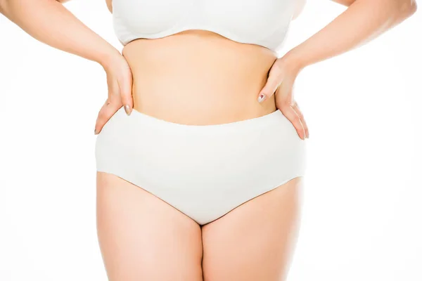 Abgeschnittene Ansicht einer übergewichtigen Frau, die mit den Händen auf der Taille posiert, isoliert auf weißem, Körper-Positivitäts-Konzept — Stockfoto