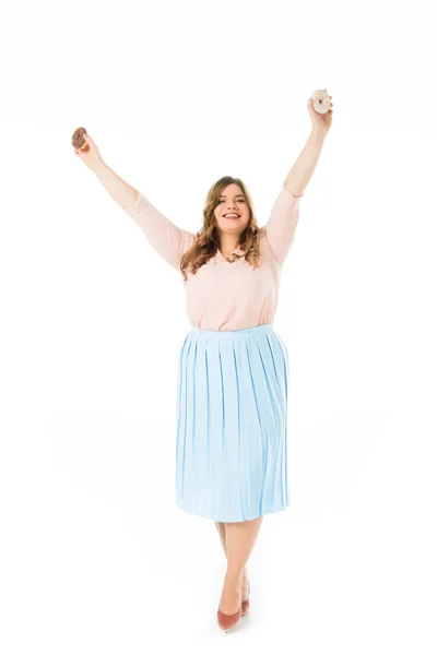 Happy elegant plus size woman holding sweet doughnuts above head isolated on white — Stock Photo