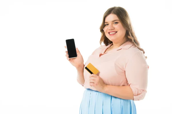 Счастливый элегантный плюс размер женщина держит смартфон с чистым экраном и кредитная карта изолированы на белом — стоковое фото