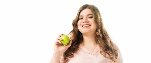 Smiling plus size young woman holding ripe green apple isolated on white — Stock Photo