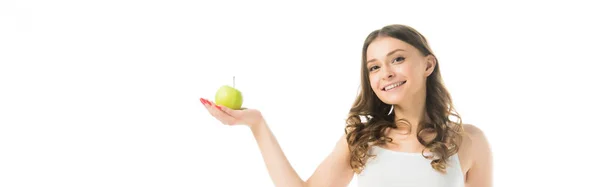 Улыбающаяся стройная молодая женщина держит спелое зеленое яблоко, изолированное на белом — стоковое фото