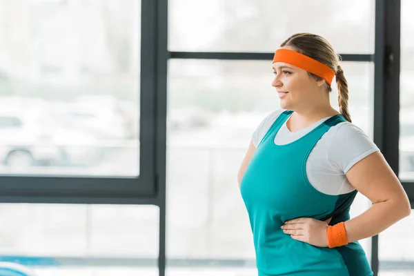 Attractive overweight woman smiling while posing in gym — Stock Photo