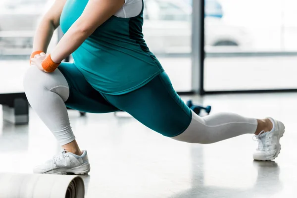 Ausgeschnittene Ansicht von Plus-Size-Frau beim Stretching im Fitnessstudio — Stockfoto
