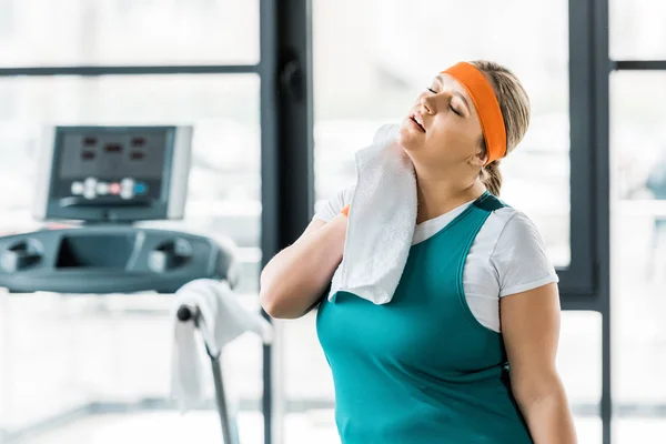 Tired plus size girl wiping sweat with towel — Stock Photo