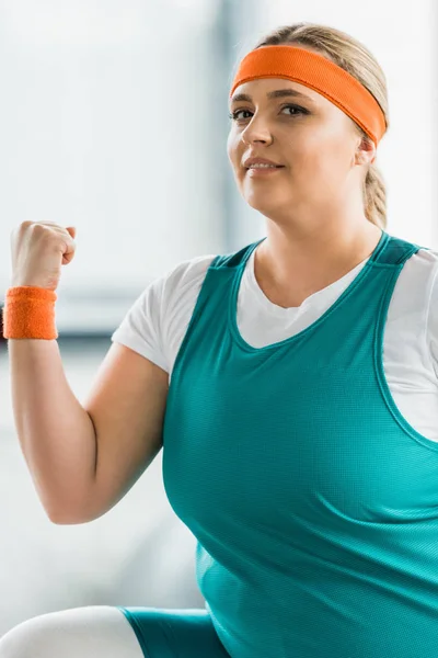 Plus size girl in sportbekleidung beim turnen im fitnessstudio — Stockfoto