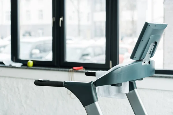 Cinta de correr moderna de pie cerca de las ventanas en el gimnasio - foto de stock