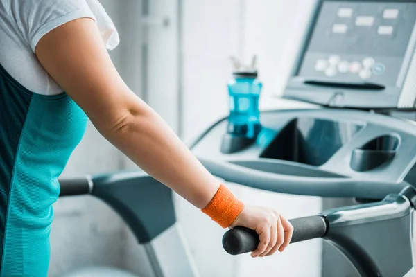 Vista recortada de la niña con sobrepeso de entrenamiento en la cinta de correr en el gimnasio - foto de stock