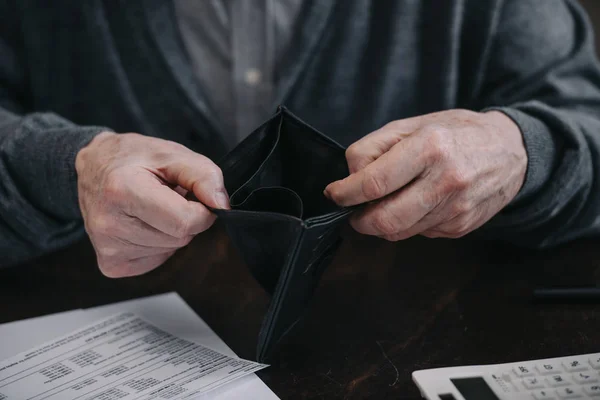 Cropped view of senior man holding empty wallet — Stock Photo