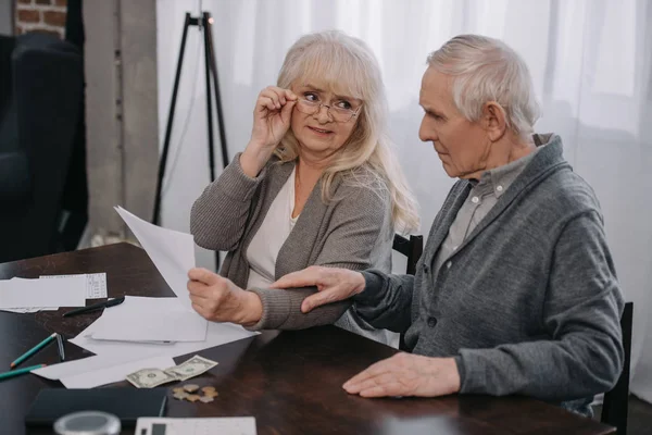 Seniorenpaar sitzt mit Dokumenten und Geld am Tisch — Stockfoto