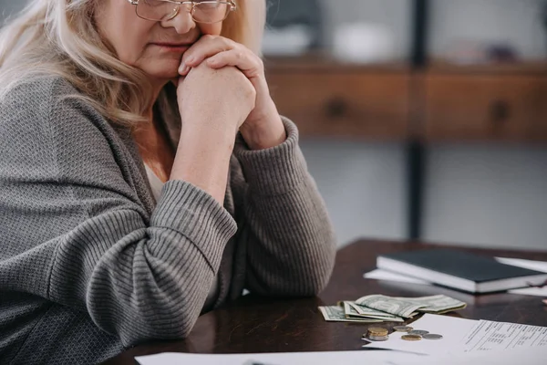 Pfarrerblick einer Seniorin, die zu Hause mit Geld am Tisch sitzt — Stockfoto