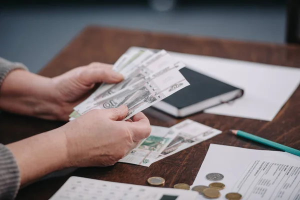 Close up of female pensioner counting money at home — Stock Photo