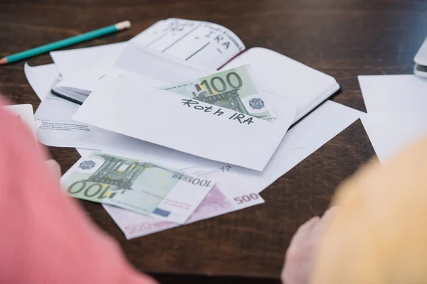 Foco seletivo do envelope com letras 'roth ira' e dinheiro na mesa — Fotografia de Stock