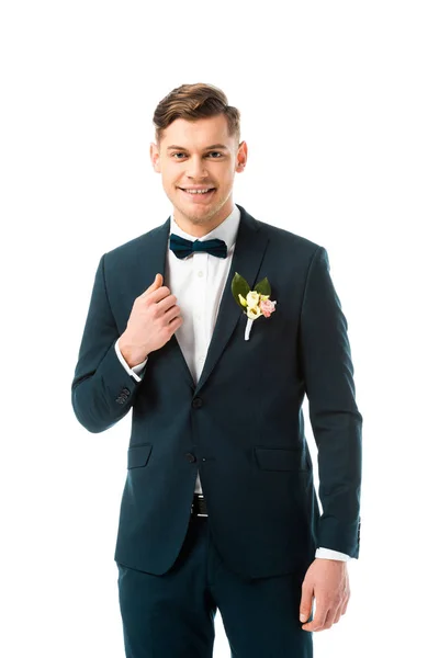 Happy handsome bridegroom in black suit looking at camera isolated on white — Stock Photo