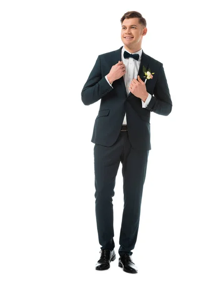 Щасливий наречений в елегантному чорному костюмі з бутоньєрою ізольований на білому — стокове фото