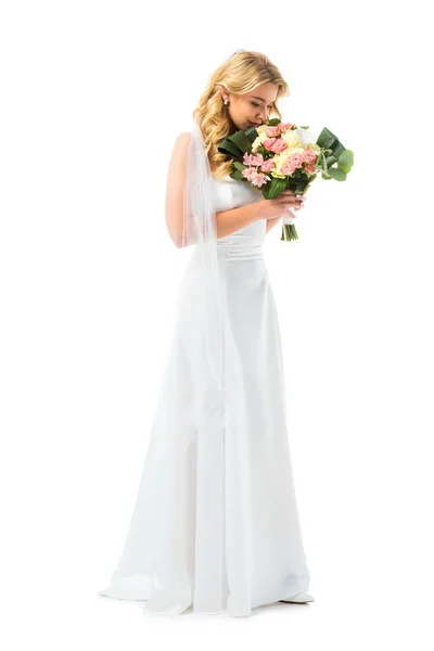 Beautiful bride enjoying flavor of wedding bouquet isolated on white — Stock Photo