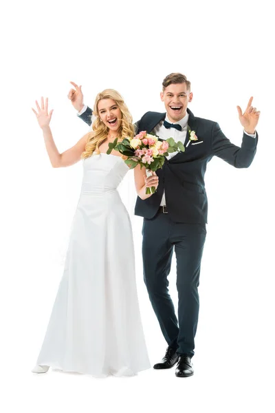 Cheerful bride and groom waving hands while looking at camera isolated on white — Stock Photo