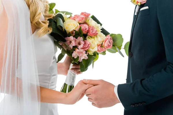 Vue recadrée de la mariée avec beau bouquet de mariage, et marié tenant les mains isolées sur blanc — Photo de stock