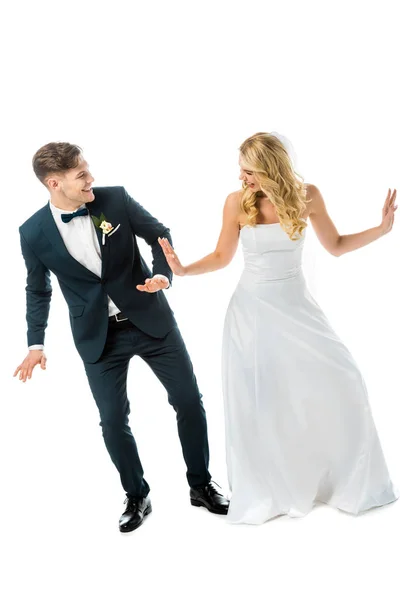 Allegro sposo in abito elegante nero danza con sposa felice in abito da sposa bianco isolato su bianco — Foto stock