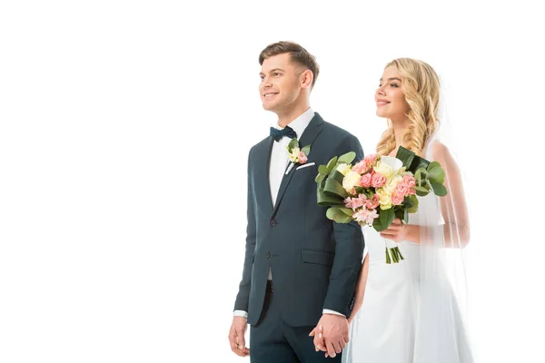 Novia feliz con hermoso ramo de boda cogido de la mano con el novio sonriente aislado en blanco - foto de stock