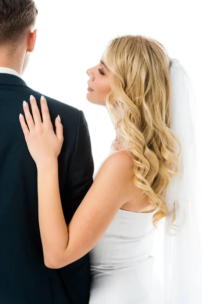 Happy bride looking at groom while standing near him isolated on white — Stock Photo