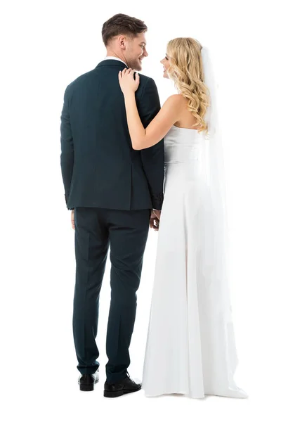 Glückliche Braut im weißen Hochzeitskleid neben lächelndem Bräutigam isoliert auf Weiß — Stockfoto