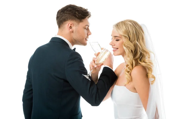 Glückliche Braut und Bräutigam trinken Champagner isoliert auf weiß — Stockfoto