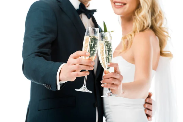 Selective focus of bride and groom clinking glasses of champagne isolated on white — Stock Photo